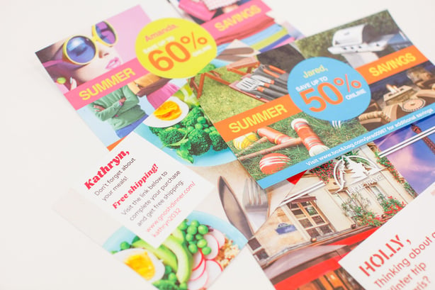 Photo of stack of brightly colored marketing materials for summer savings.