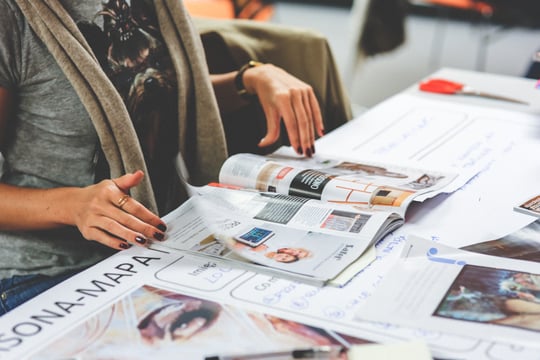 Photo of hands flipping through print materials.