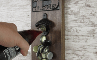 This image contains a wall-mounted bottle opener and a bottle being opened.